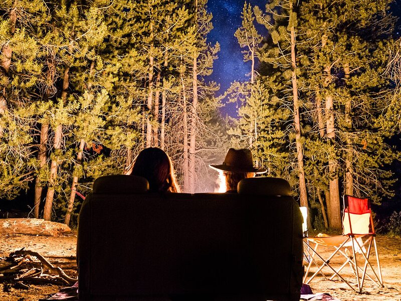 A couple by a campfire under the pines