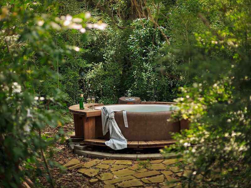 A wooden hot tub outside a cabin